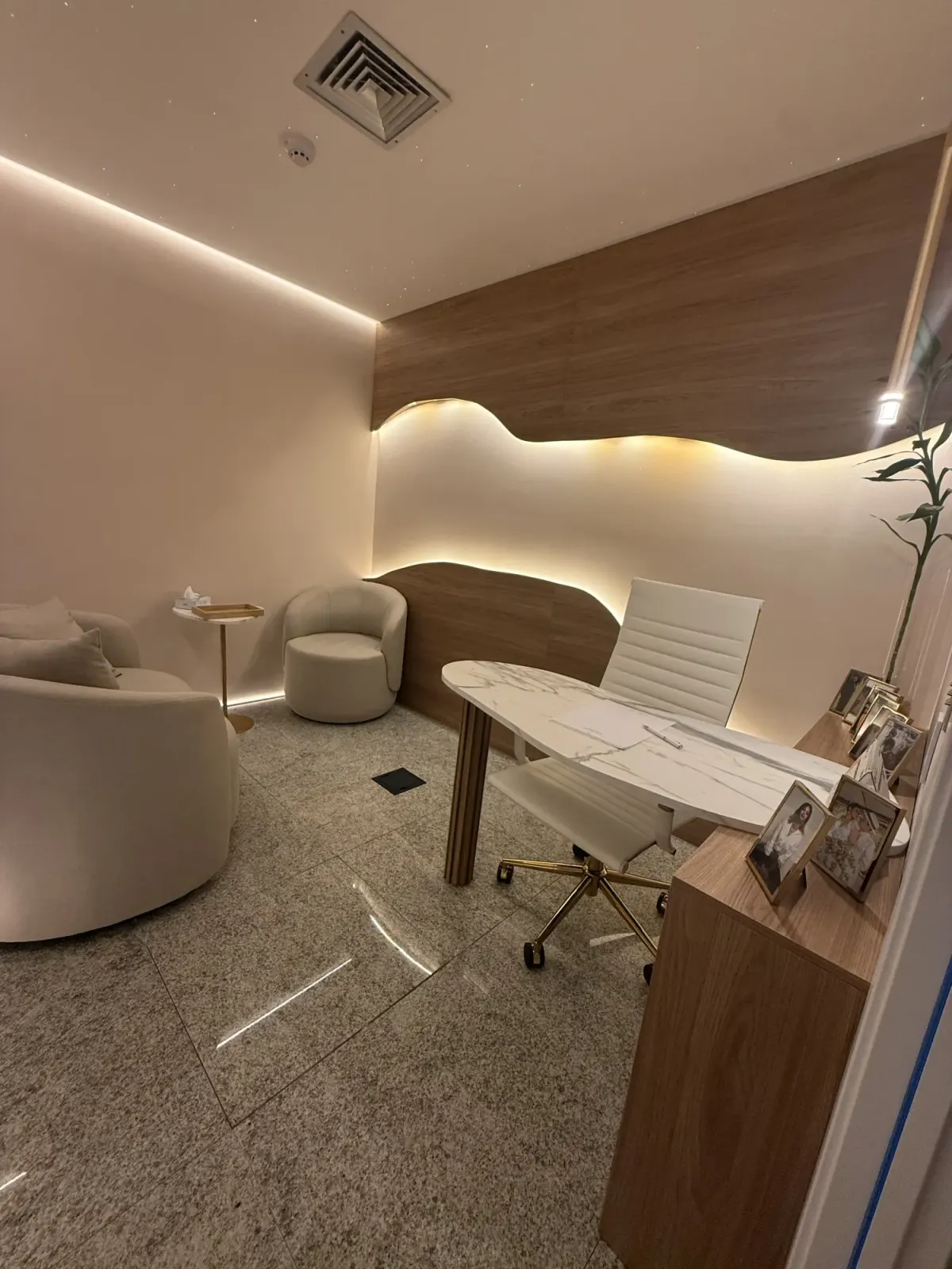 Sala de atendimento à luz do dia, com madeira, mármore e materiais naturais